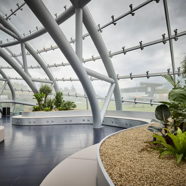 Innenansicht des Hangar-7 mit Glas-Stahl-Architektur, Sitzgelegenheiten und Pflanzen 