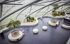 Interior view of Hangar-7 showing its glass-and-steel architecture, seating arrangements and plants
