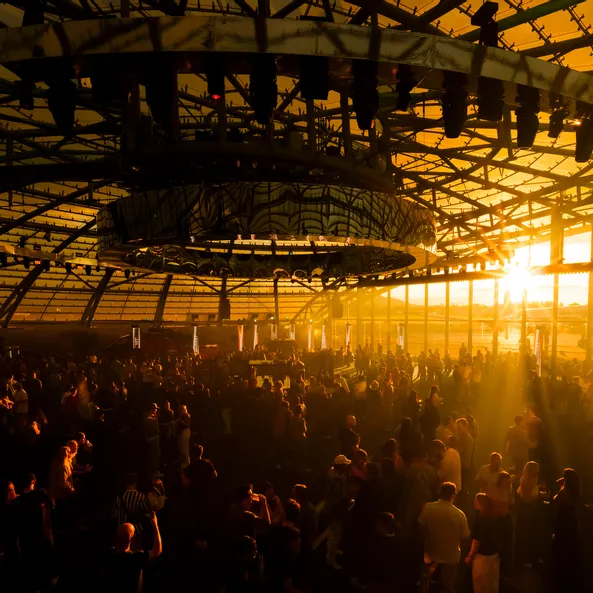 Das Sunset-Event im Red Bull Hangar-7 bei Sonnenuntergang, der die gesamte Halle und das Publikum in goldenes Licht taucht.