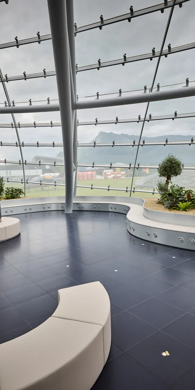 Interior view of Hangar-7 showing its glass-and-steel architecture, seating arrangements and plants