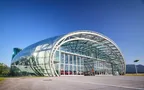 Exterior view of Hangar-7 with open gate, revealing exhibits inside the exhibition area