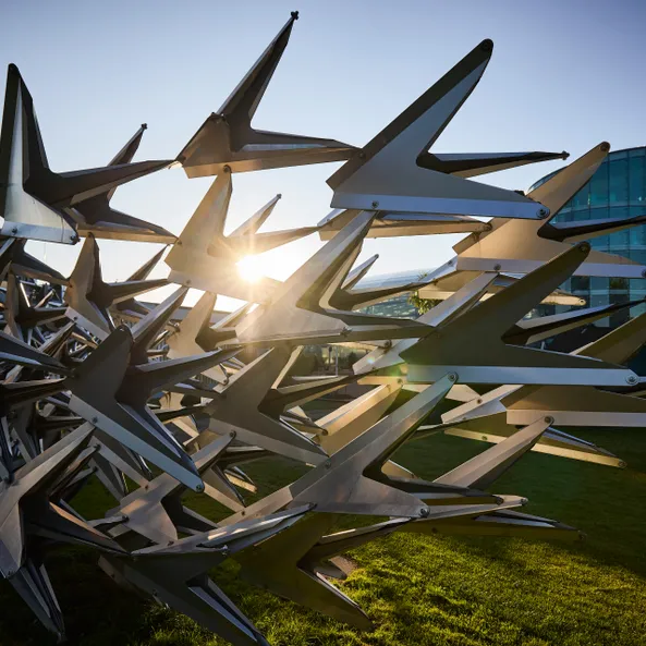 Metal sculpture in front of the glass architecture of Hangar-7